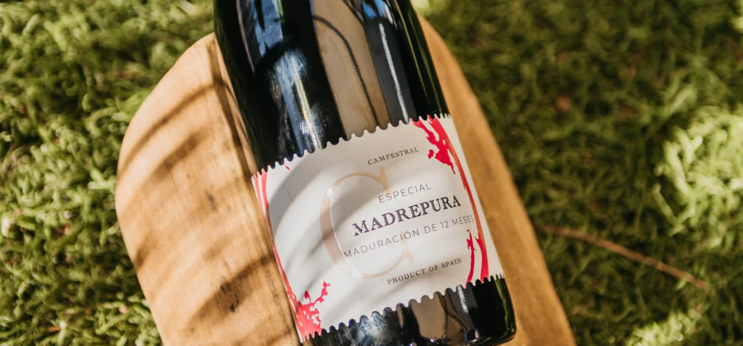 Botella de vino sobre mesa de madera anunciando próximas catas en Wine Not? La Barrosa